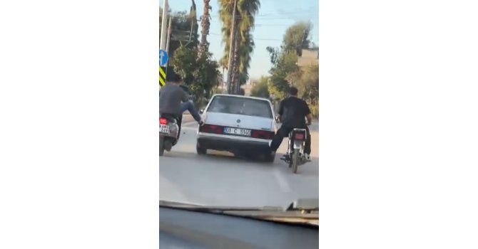 Motosikletliler, yolda kalan otomobili ayaklarıyla ittirdi