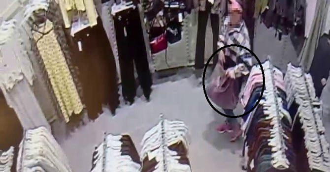 Alışveriş merkezinde çocuğunun yanında hırsızlık yapan kadın kamerada