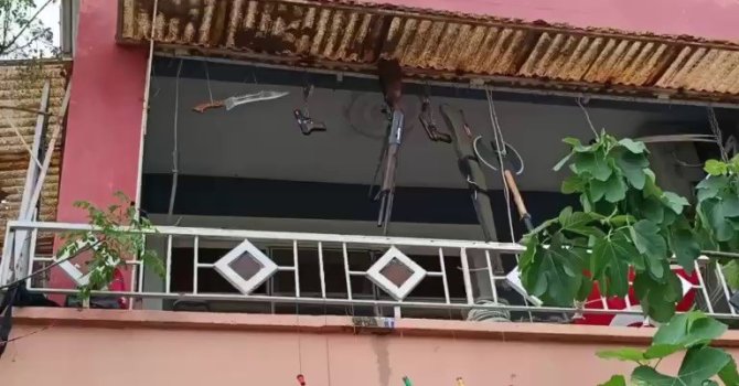 Balkonda silah, balta ve kılıç sergileyen şahıs hayrete düşürdü