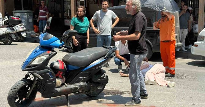 Kazada yaralanan genç kadına esnaftan şemsiyeli destek