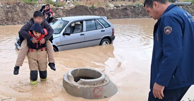 İtfaiyeci, göle dönen yolda mahsur kalan çocuğu sırtında taşıyarak kurtardı