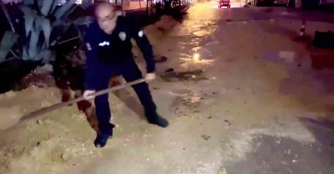 Araçlar zarar görmesin diye küreği eline alan polis memurları, suyla dolan çukurları toprakla doldurdular