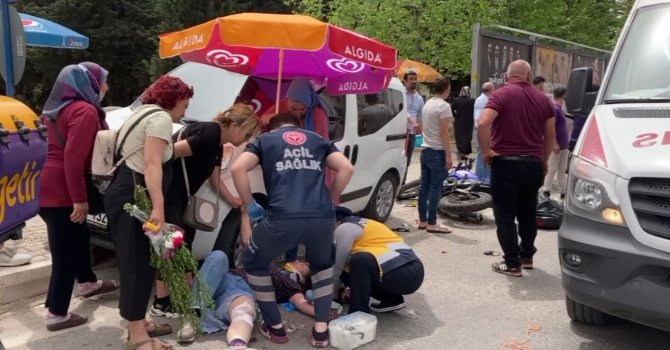 Kazada acı içinde yerde yatan kadına hemcinsinden plaj şemsiyeli koruma