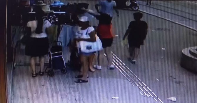 Birisi perdeledi, diğeri askıda duran şortları pazar arabasına doldurdu