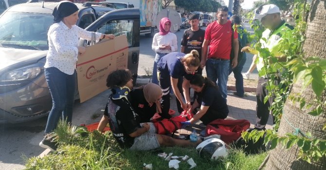 Yerde acı içerisindeki yaralıyı yakıcı güneşten kartonla korudular