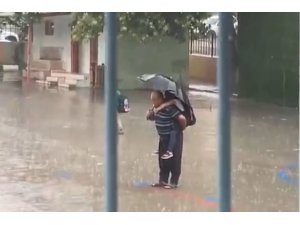 Dede torununu sırtına alarak yağmur altında İstiklal Marşı okudu