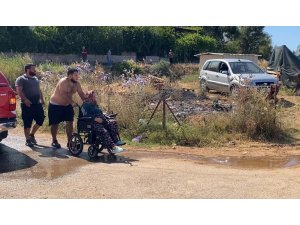Evine yaklaşan alevlerden kurtarılan kadın tekerlekli sandalyeyle bölgeden uzaklaştırıldı