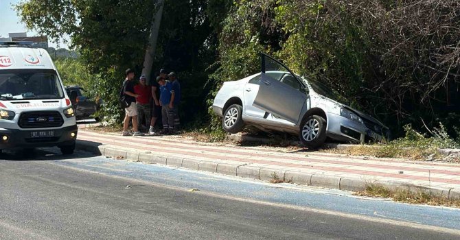 Kaldırıma çıkıp asılı kalan otomobildekiler kazayı burnu bile kanamadan atlattı