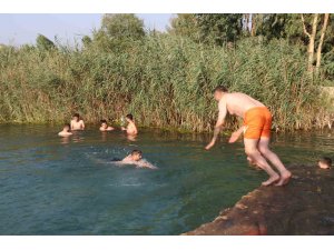 Adana’da gençler bunaltan sıcakta gölette serinledi