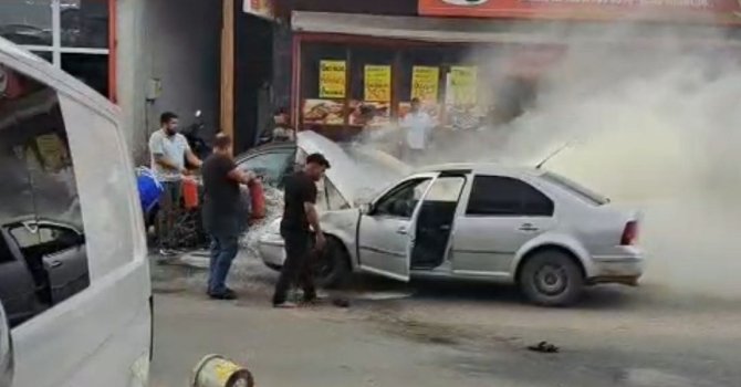 Adana’da yanan otomobili esnaf su ve yangın tüpüyle söndürdü