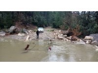 Derenin debisi yükselince aracıyla mahsur kaldı