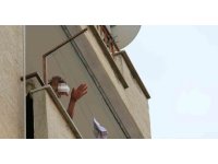 Sinir krizi geçirip kapıyı üzerine kilitleyen genç adam, eline geçen tüm eşyaları sokağa fırlattı