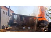 Evinin etrafını saran alevlere gözyaşları içinde hortumla müdahale etti