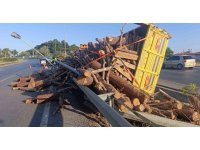 Tomruk yüklü kamyon bariyerleri aşıp refüje devrildi