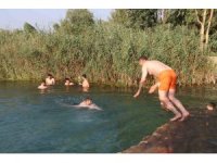 Adana’da gençler bunaltan sıcakta gölette serinledi